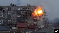 ARCHIVO - Un disparo de un tanque ruso impacta en un edificio de apartamentos de Mariúpol, Ucrania, el 11 de marzo de 2022. La imagen es parte del documental "20 días en Mariúpol" de la agencia AP.