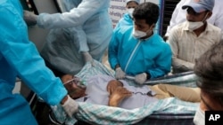 Los trabajadores de la salud llevan a un paciente después de un incendio en el hospital Vijay Vallabh en Virar, cerca de Mumbai, India, el 23 de abril de 2021.