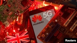 资料照：在一块电脑母版上的英国国旗和有着华为与5G网络标识的手机。（2020年1月29日）