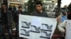 A protester in Ramallah holds a picture of a young Gazan girl and says the violence must stop. He blames Israel but says his leadership must do more. (R.Collard/VOA)