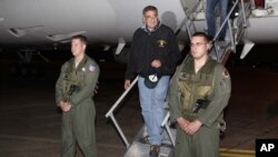U.S. Defense Secretary Leon Panetta, center, steps off his jet after arriving at Yokota Air Base on the outskirts of Tokyo, Japan, Sunday, Sept. 16, 2012. 