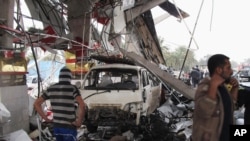 Warga sipil memeriksa lokasi serangan bom di Hillah, 95 kilometer sebelah selatan Baghdad, Irak (9/4).