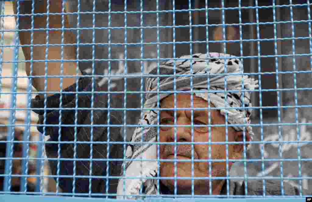 A Palestinian man stands in a symbolic prison cell during a protest supporting Palestinian inmates on hunger strike in Israeli jails, in the West Bank city of Ramallah, May 14, 2012.