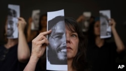 Familiares y defensores de los rehenes cautivos por Hamás en Gaza, sostienen fotografías de sus seres queridos durante una protesta para reclamar su vuelta, en Tel Aviv, Israel, el 23 de mayo de 2024.