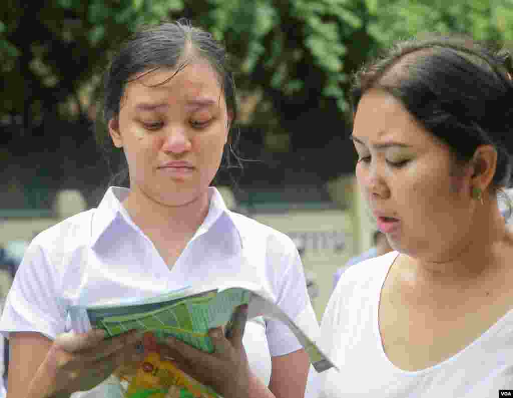 បេក្ខជនារីប្រឡងបាក់ឌុបមើលខិត្តប័ណ្ណផ្សព្វផ្សាយអំពីព័ត៌មានសិក្សា បន្ទាប់ពីខ្លួននចេញពីមណ្ឌលប្រឡងថ្ងៃចុងក្រោយនៅវិទ្យាល័យព្រះយុគន្ធ នៅថ្ងៃអង្គារ ទី២៣ ខែសីហា ឆ្នាំ២០១៦ នៅរាជធានីភ្នំពេញ។ (ឡេង ឡែន/VOA)