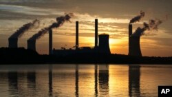 FILE - The coal-fired Plant Scherer, one of the nation's top carbon dioxide emitters, stands in the distance in Juliette, Ga., June 3, 2017. 