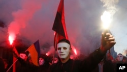Members of the nationalist movements light flares during a rally marking Defense of the Homeland Day in center Kyiv, Ukraine, Oct. 14, 2019. 