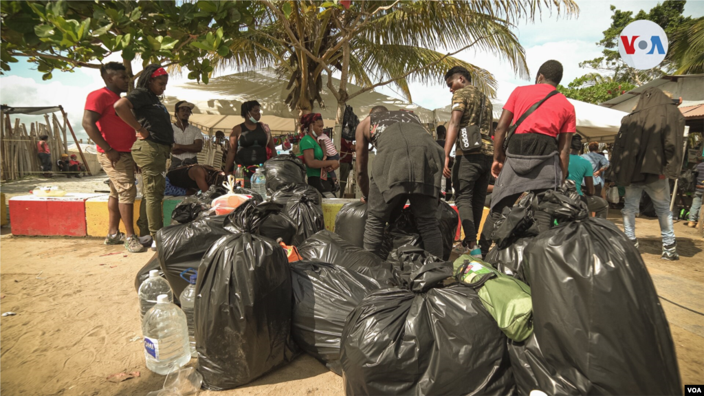 Un grupo de migrares africanos empacan sus pertenencias en bolsas de basura para iniciar la travesía que los llevará a cruzar el mar abierto y enfrentarse a los peligros del Tapón del Darién.