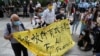 Aktivis pro-demokrasi Figo Chan, Avery Ng dan lainnya memegang spanduk di depan media sebelum persidangan atas dakwaan terkait sidang tidak sah pada 1 Oktober 2019, di luar pengadilan di Hong Kong, China, 17 Mei 2021. (Foto : REUTERS/Lam Yik)