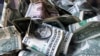A tip box is filled with dollar bills, Wednesday, April 3, 2019, in New York. (AP Photo/Mark Lennihan)