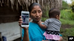 Claudia Maquin, de 27 años, muestra una foto de su hija Jakelin Amei Rosmery Caal Maquin en Raxruha, Guatemala, el sábado 15 de diciembre de 2018.