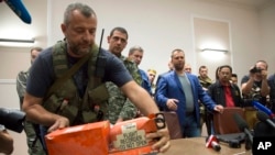 Ukraina sharqidagi isyonchilar Malayziya Havo Yo'llari vakiliga urib tushirilgan Boing samolyotidan topilgan qora qutini topshirmoqda, Donetsk, 22-iyul, 2014-yil