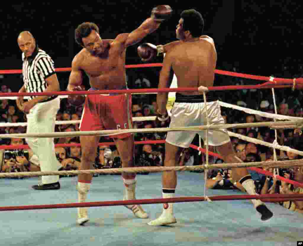 Muhammad Ali, à droite, dévie un coup de poing de George Foreman, culotte rouge, à Kinshasa, au Zaïre, le 29 Octobre, 1974. Ali a remporté le combat en Afrique par un knock-out au cours du 8ème tour. Zack Clayton est l’arbitre. (AP Photo)
