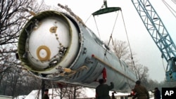 Soldiers prepare to destroy a ballistic SS-19 missile in the yard of the largest former Soviet military rocket base in Vakulenchuk, Ukraine, December 24, 1997. 