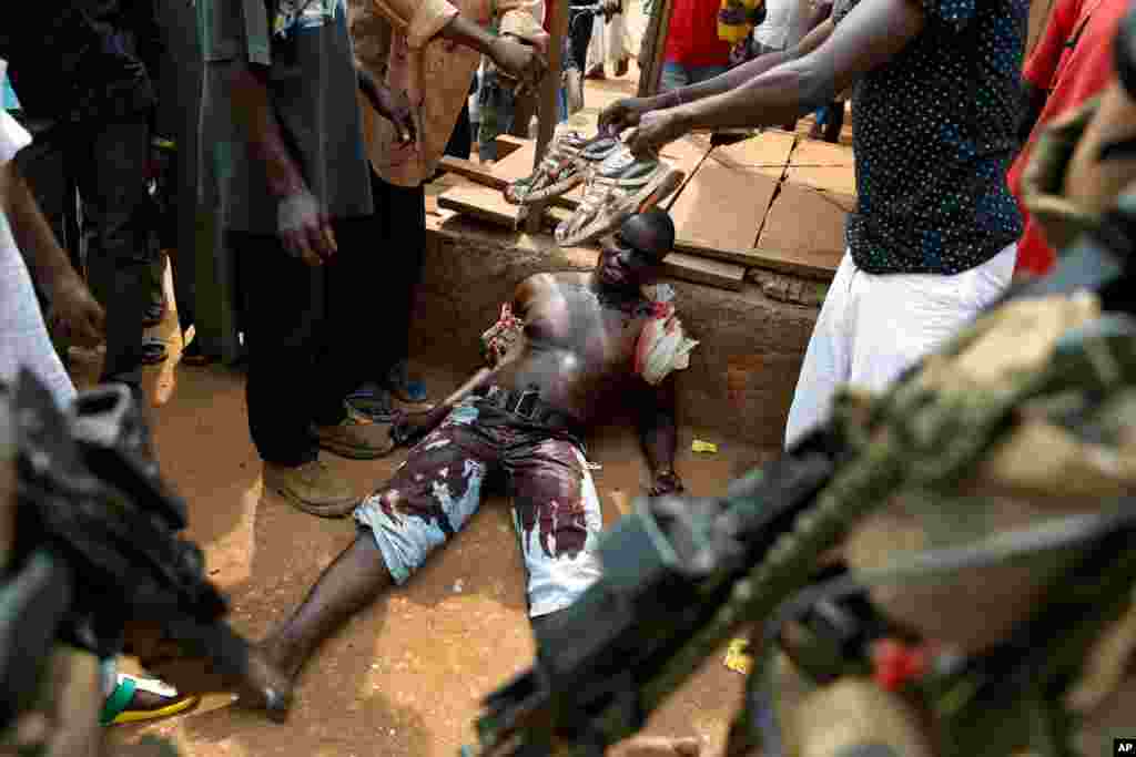 A suspected member of a militia lays wounded by machete blows in the Kokoro neighborhood of Bangui, Central African Republic, Dec. 9, 2013.