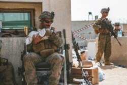 A Marine assigned to the 24th Marine Expeditionary Unit calms an infant during an evacuation at Hamid Karzai International Airport, in Kabul, Afghanistan, Aug. 20, 2021. (Sgt. Isaiah Campbell/U.S. Marine Corps via AP)