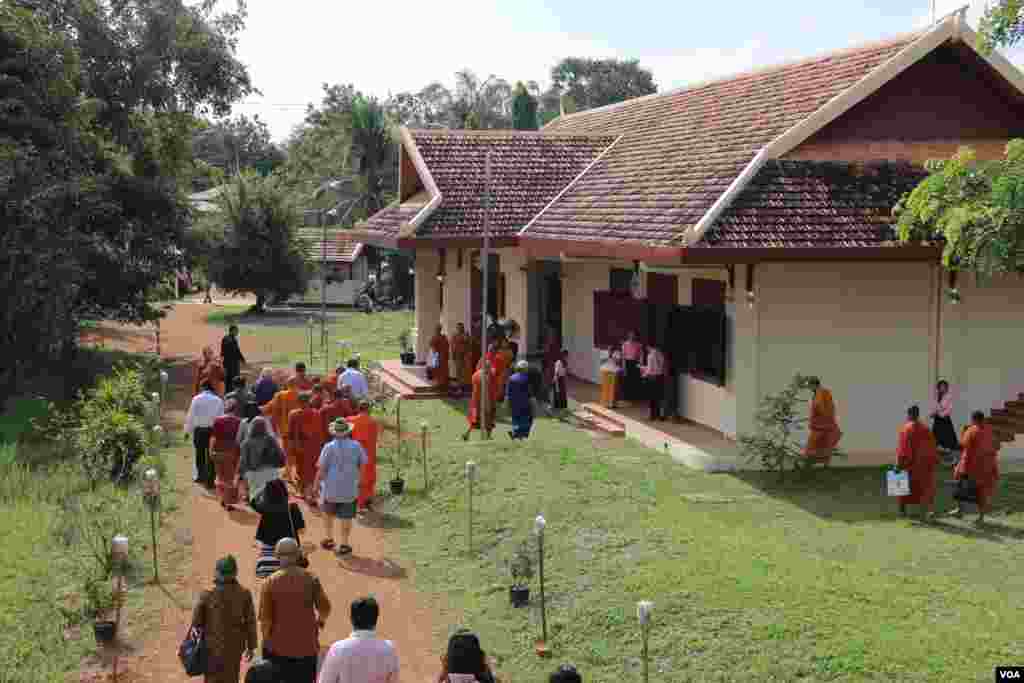 អ្នកចូលរួមទស្សនាបានដើរតាមក្បួនដង្ហែរសូត្រមន្តរបស់ព្រះសង្ឃកាត់ទីធ្លាពិព័រណ៍សន្តិភាព ទៅកាន់សាលមួយដែលមានតាំងរូបសិល្បៈឆ្លុះបញ្ចាំងអំពីកិច្ចខិតខំប្រឹងប្រែងក្នុងការព្យាបាលដំបៅសង្គ្រាមនៅកម្ពុជា ដូចជាការដោះមីន និងការគាំពារជនរងគ្រោះដោយសារសង្គ្រាមជាដើម។ (រិទ្ធី ឧត្តម/VOA)