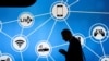 A man looks at his phone in front of a stand at the Mobile World Congress in Barcelona, Spain, showing a variety of devices connected via Wi-Fi and Internet of Things networks, Feb. 28, 2017