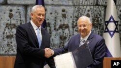 Israeli President Reuven Rivlin, right, hands a mandate to form new government to Blue and White Party leader Benny Gantz, in Jerusalem, Oct. 23, 2019.