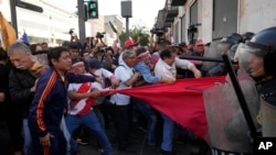 Manifestantes antigubernamentales se enfrentan a policías antidisturbios cerca del palacio de gobierno en Lima, Perú, el 5 de noviembre de 2022. 