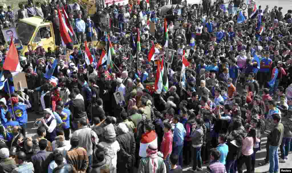 This SANA photo shows supporters of Syrian President Bashar al-Assad attend a rally in Salkha, Sweida, southern Syria, March 4, 2014.