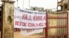 In this photo taken on Sunday, Sept. 14, 2014, a sign reading 'Kill Ebola Before Ebola Kill You', on a gate forming part of the country's Ebola awareness campaign in the city of Freetown, Sierra Leone. Shoppers crowded streets and markets in Sierra Leon