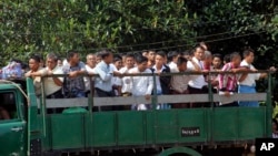 Myanmar prisoners ride a truck as they were released from Insein prison Tuesday, Oct. 7, 2014.