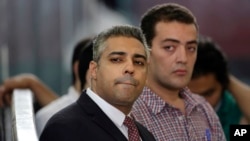 Wartawan Al-Jazeera Mohammed Fahmy, kiri, dalam persidangan di penjara Tora, Kairo, Mesir, 4 Juni 2015.