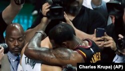 Košarkaš Klivlend Lebron Džejms grli rukija Bostona Džejsona Tejtuma na kraju sedme utakmcie finala Istočne konferencije u Bostonu, 27. maja 2018. (Foto: AP/Charles Krupa))