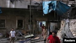 Petugas medis memeriksa kerusakan di luar rumah sakit yang terkena serangan udara di kawasan yang dikuasai pemberontak di al-Maadi, Aleppo, Suriah, 28 September 2016. 