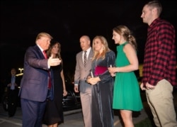 President Donald Trump. left, and first lady Melania Trump greet lead pastor Jimmy Scroggins, his wife, Kristin, and their son and daughter-in-law, James, right, and Reilly as they arrive at the Family Church Downtown for a Christmas Eve service.
