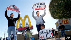 Demonstrasi pekerja restoran cepat saji yang menuntut kenaikan upah minimum di Phoenix, Arizona pada Desember 2013. 