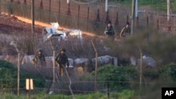 FILE - Israeli soldiers work on a military vehicle that was hit by a missile fired by Hezbollah on the Israel-Lebanon border, Jan. 28, 2015.