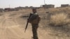 A Peshmerga fighter patrols a village retaken from IS militants during the latest offensive toward Mosul, June 6, 2016. (S. Behn/VOA)
