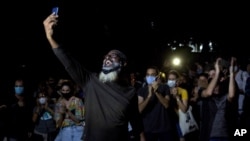 Jóvenes artistas protestan frente a las puertas del Ministerio de Cultura, en La Habana, Cuba, el viernes 27 de noviembre de 2020. Decenas de artistas cubanos protestaron contra la policía que desalojó a un grupo que participaba en una huelga de hambre.