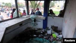 Las personas observan una estación de Policía vandalizada en Bogotá, durante las protestas contra la pobreza y la violencia policial que estallaron en la última semana de abril de 2021.