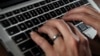 FILE- A person types on a laptop keyboard in North Andover, Mass, June 19, 2017. 