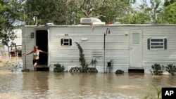 Una mujer sale de su casa móvil en medio de una inundación en el condado de Harris, cerca de Houston, Texas, el 4 de mayo de 2024. 