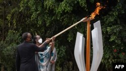 Président ya Rwanda Paul Kagame (G) na molongani wa ye Jeannette Kagame bazali kopelisa mwinda na milulu mya mibu 27 mya bobomi bonene to génocide, na Kigali, Rwanda, le 7 avril 2021.
