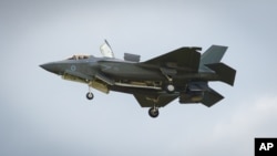 FILE - The F-35 Lightning II hovers in front of crowds during its first solo appearance at the Farnborough Air Show in the United Kingdom, July 12, 2016.