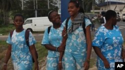 Des élèves se promènent dans une rue de Libreville, Gabon, 15 juin 2009.