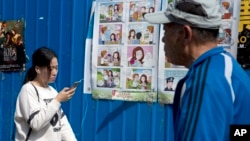 Warga berjalan melewati poster kamapanye anti-spionase di salah satu sudut kota Beijing, China, 20 April 2016 (Foto: dok).