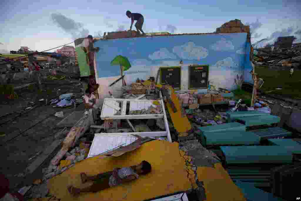 Children who survived Typhoon Haiyan play on top of the ruins of their destroyed primary school in Guiuan, Philippines, Nov. 14, 2013. 