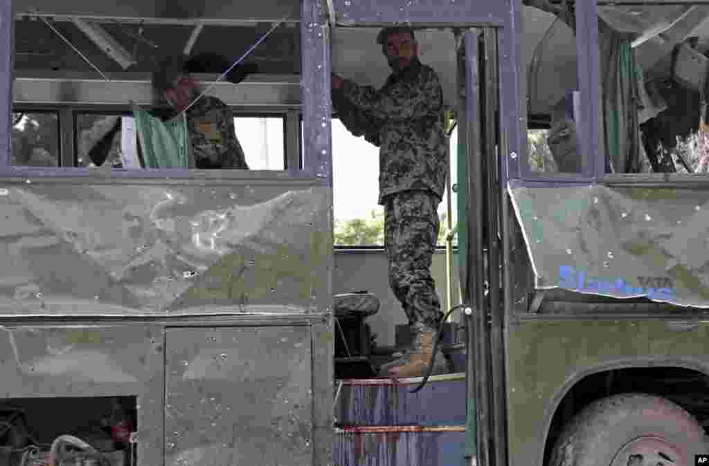 Afg'on askarlari portlash oqibatida yaroqsiz holga kelgan avtobusni yo'ldan olishga hozirlanmoqda, Kobul, 2-iyul, 2014-yil.