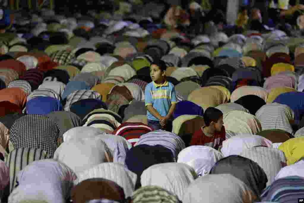 A boy stands among the supporters of ousted Egypt's President Mohamed Morsi, who are offering the the Tarawih prayer, after the evening meal when Muslims break their fast during Ramadan, in Nasr City, Cairo, July 10, 2013.