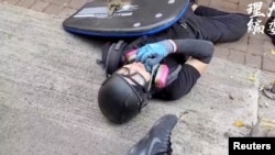 一名香港反送中抗議者被警察發射的子彈打中倒在地上。（2019年10月1日） 