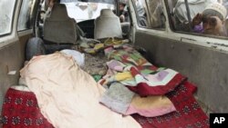 An Afghan boy peeks into a bus carrying the body of a person who was allegedly killed by a U.S. service member in Panjwai, Kandahar province south of Kabul, Afghanistan, March 11, 2012