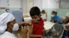 Luis Duarte, de 5 años, recibe una dosis de la vacuna Sinopharm contra la enfermedad del coronavirus (COVID-19) para asegurar la protección contra la variante del coronavirus ómicron, en Caracas, Venezuela, el 9 de diciembre de 2021.