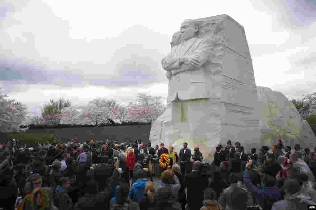 2018年4月4日,华盛顿特区,马丁·路德·金纪念园, 一座高9米的马丁.路德.金雕像之下,人们集会纪念Martin Luther King Jr.牧师遇刺50周年。时值樱花季节。马丁.路德.金雕像由中国雕刻家雷宜锌制作。雕像上,马丁.路德.金从巨石中出现,表情凝重,双臂交叉,左手紧握文稿。