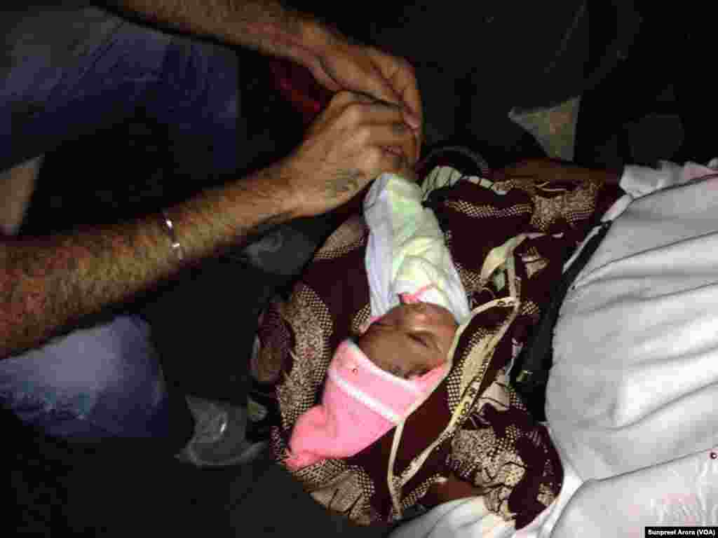 The thumb of an infant is scanned using an optical reader in a Benin health clinic. (Sunpreet Arora)